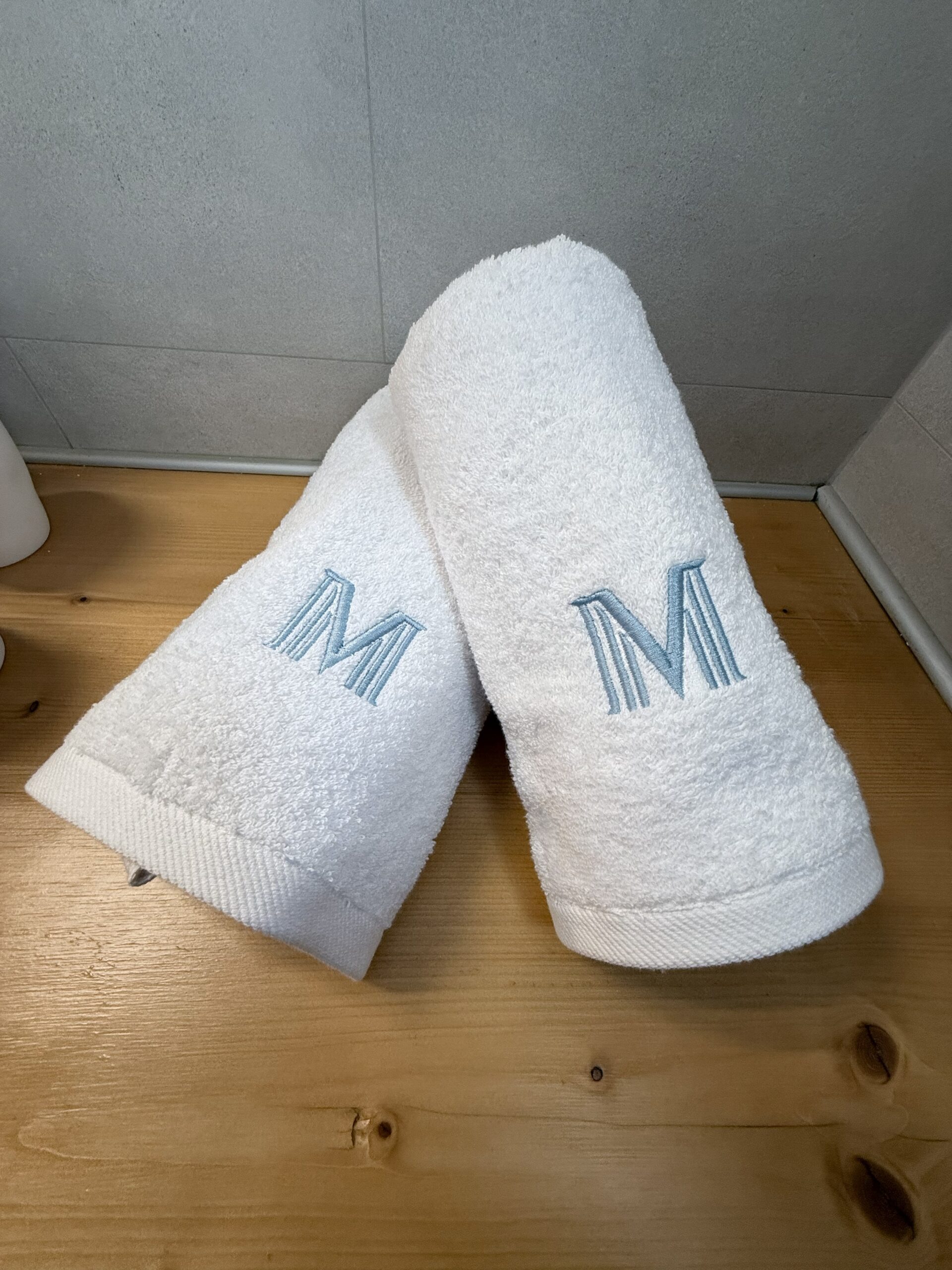 Soft white towels embroidered with the Villa Manesi monogram