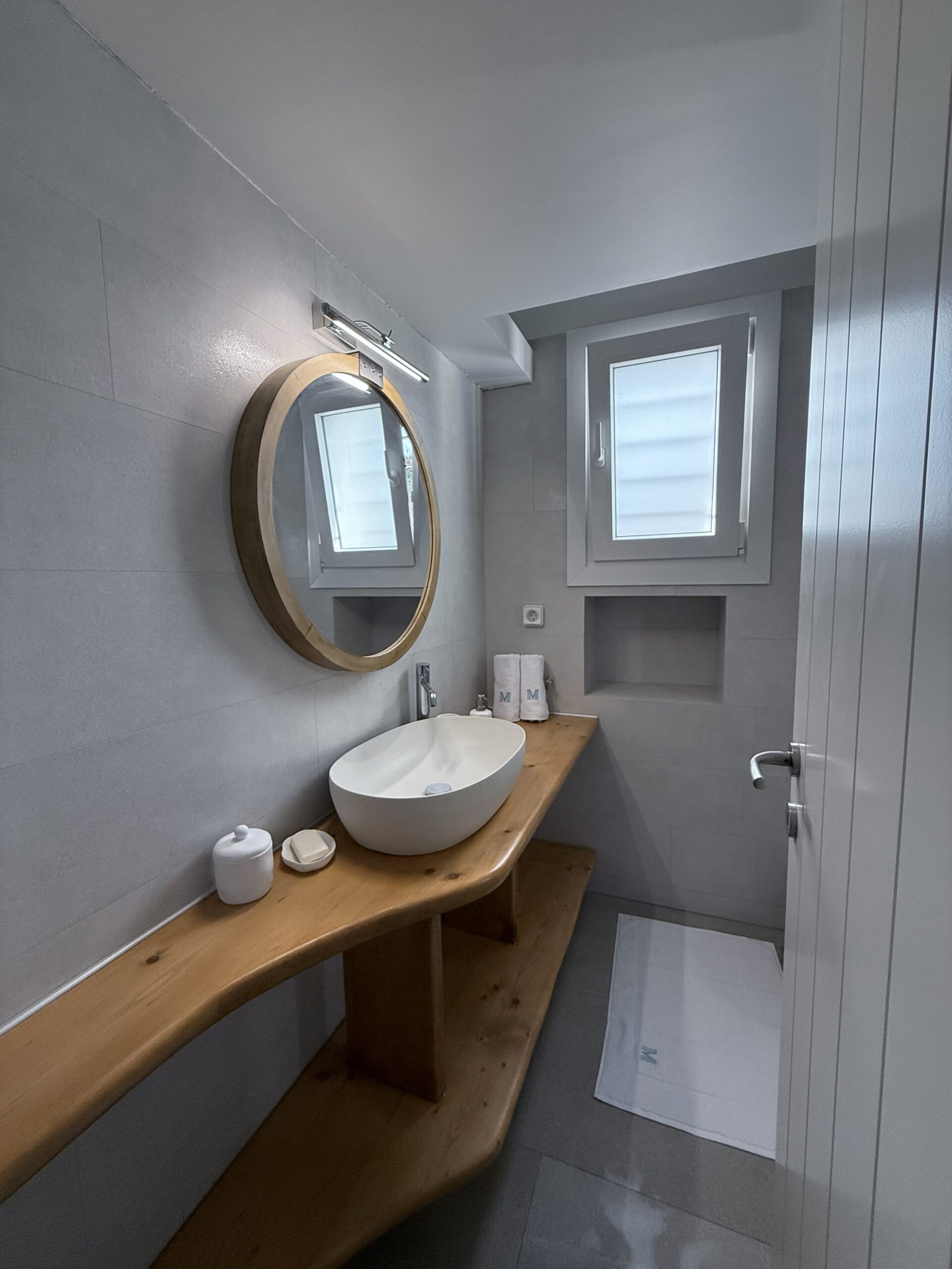 Elegant en-suite bathroom with natural wood details and soft daylight