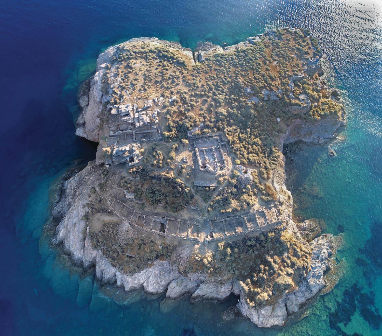 Aerial view of Vryokastro archaeological site surrounded by the Aegean Sea